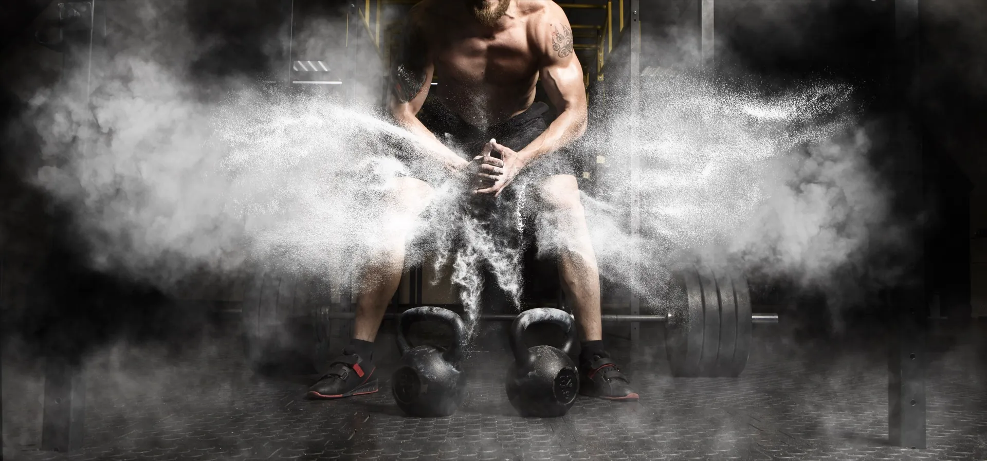 Man lifting weights with chalk powder representing strength and vitality from testosterone therapy at Rewind Anti-Aging Miami