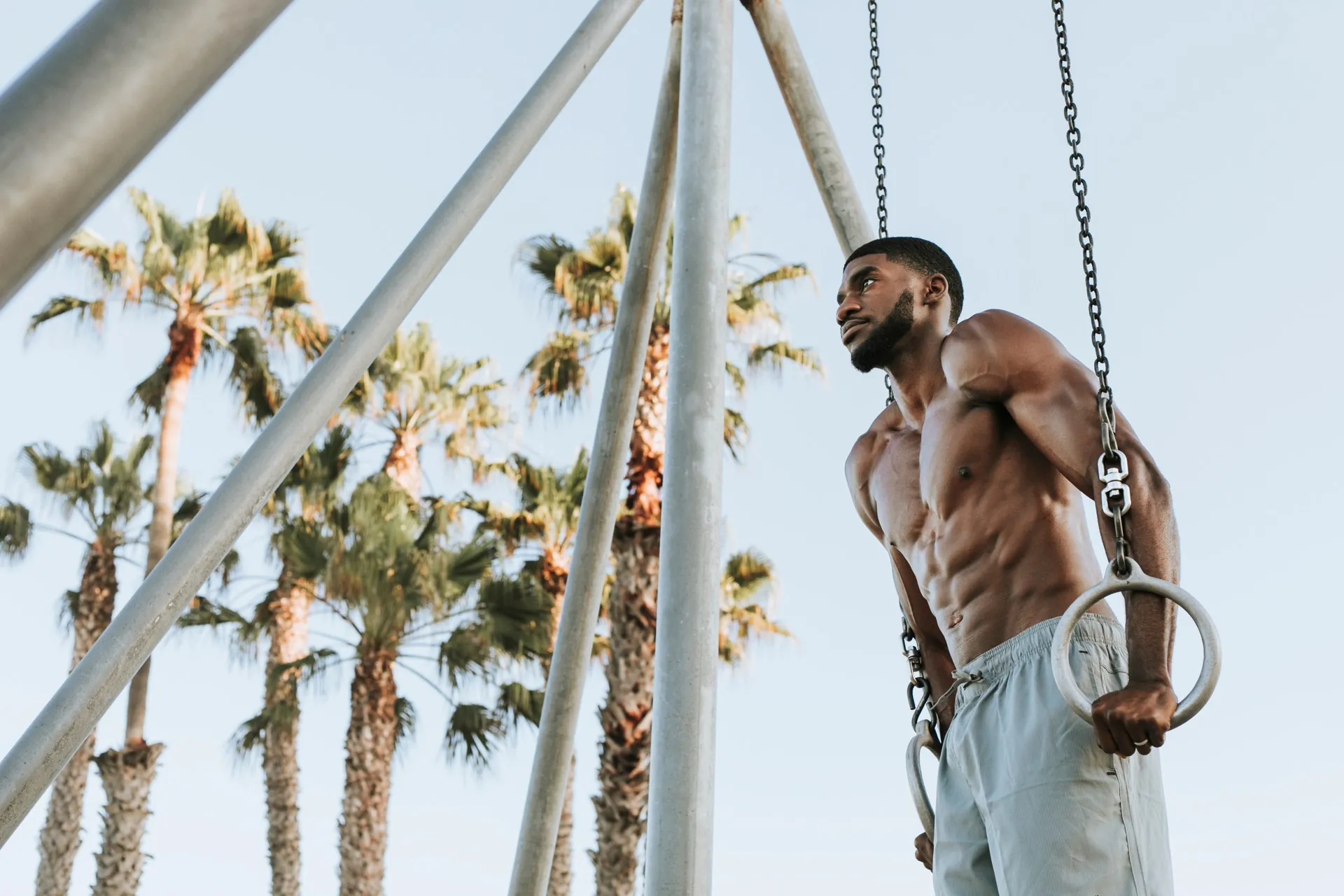 Athletic man on rings representing recovery and healing with TB-500 at Rewind Anti-Aging Miami