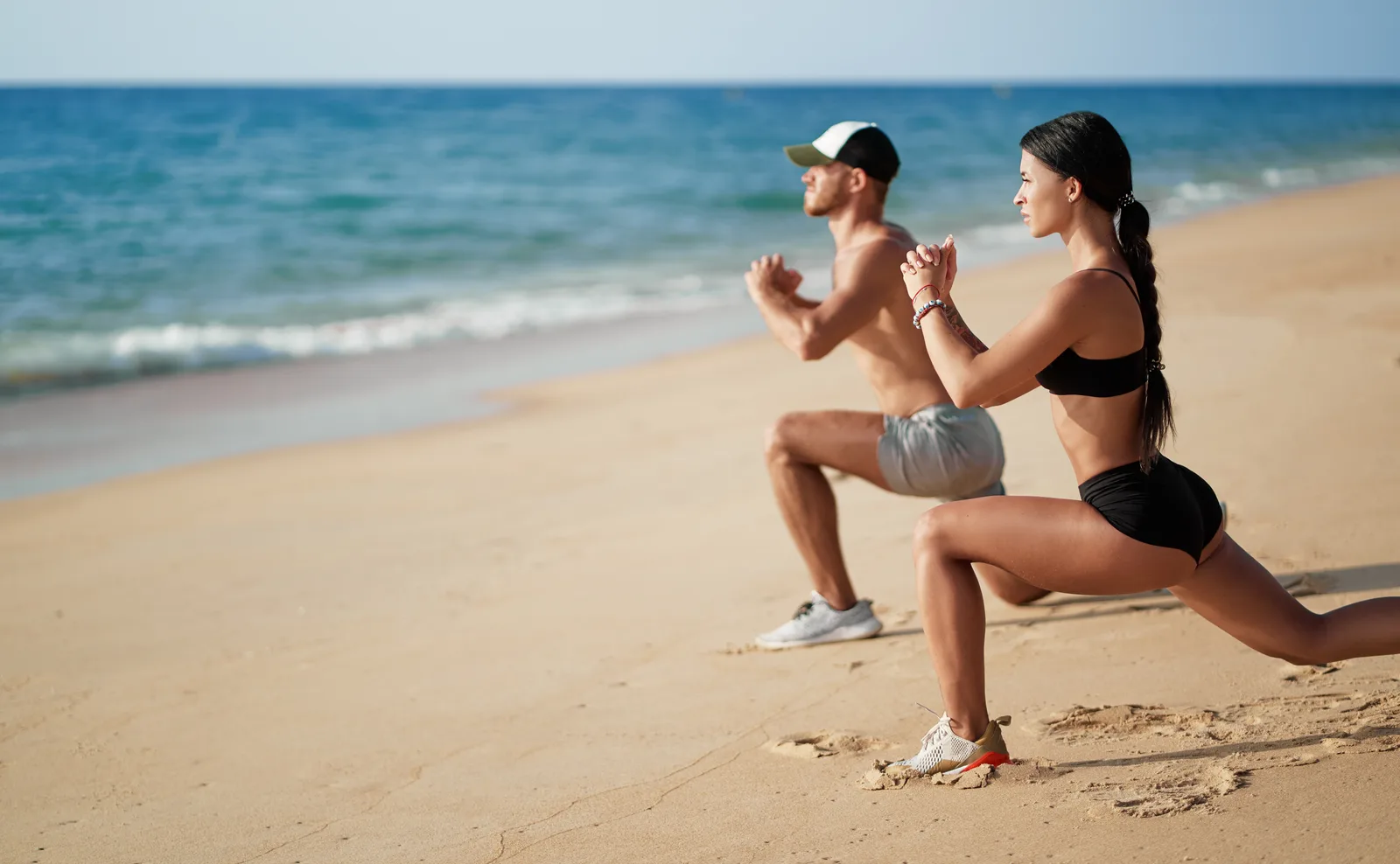 Active couple doing a beach workout — integrated aesthetic, peptide, and hormone care for Aventura