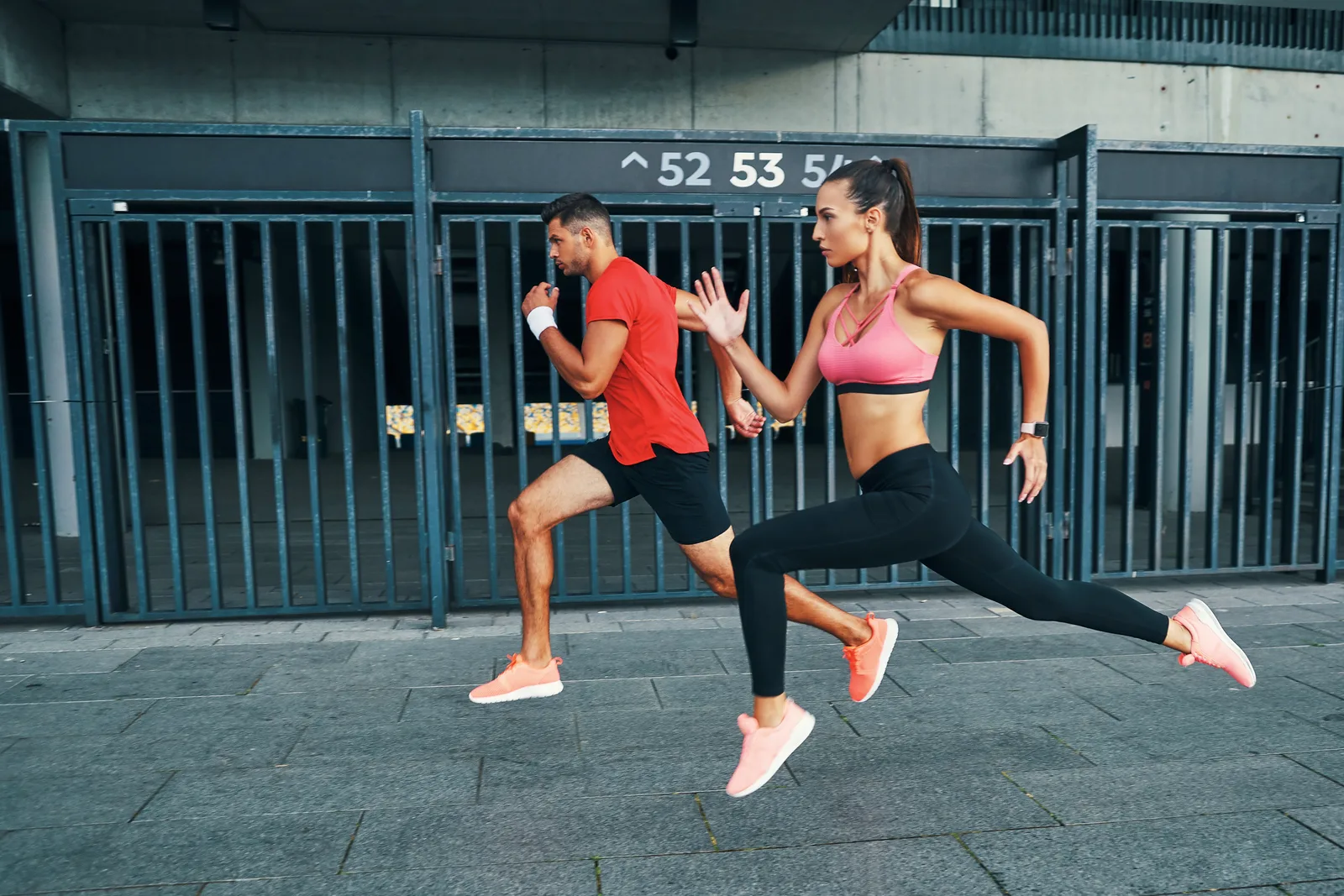 Active urban couple sprinting in the Wynwood and Midtown corridor where Rewind Anti-Aging is located
