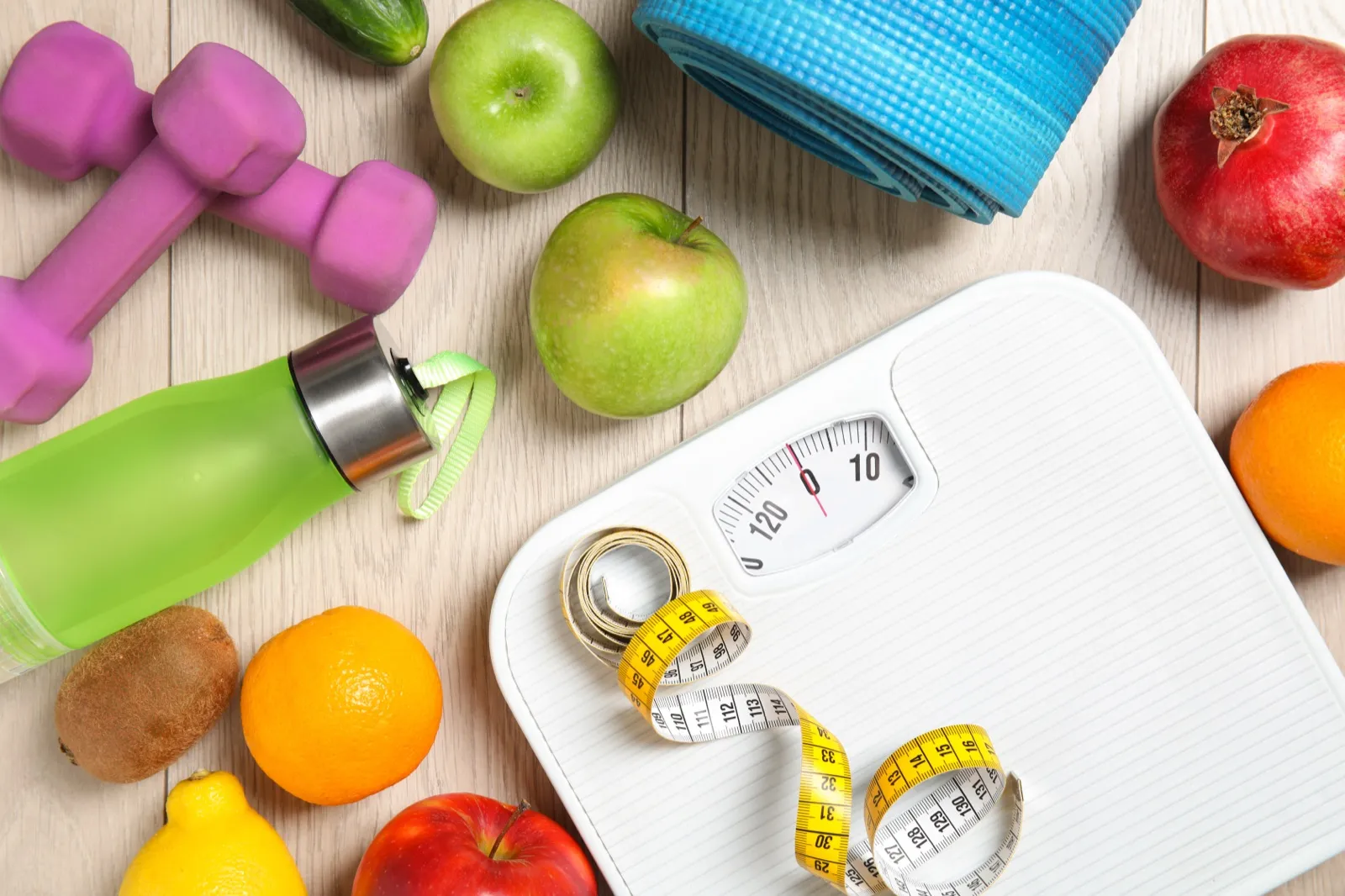Healthy lifestyle with scale, fruits, and exercise equipment for holistic weight management at Rewind Anti-Aging Miami