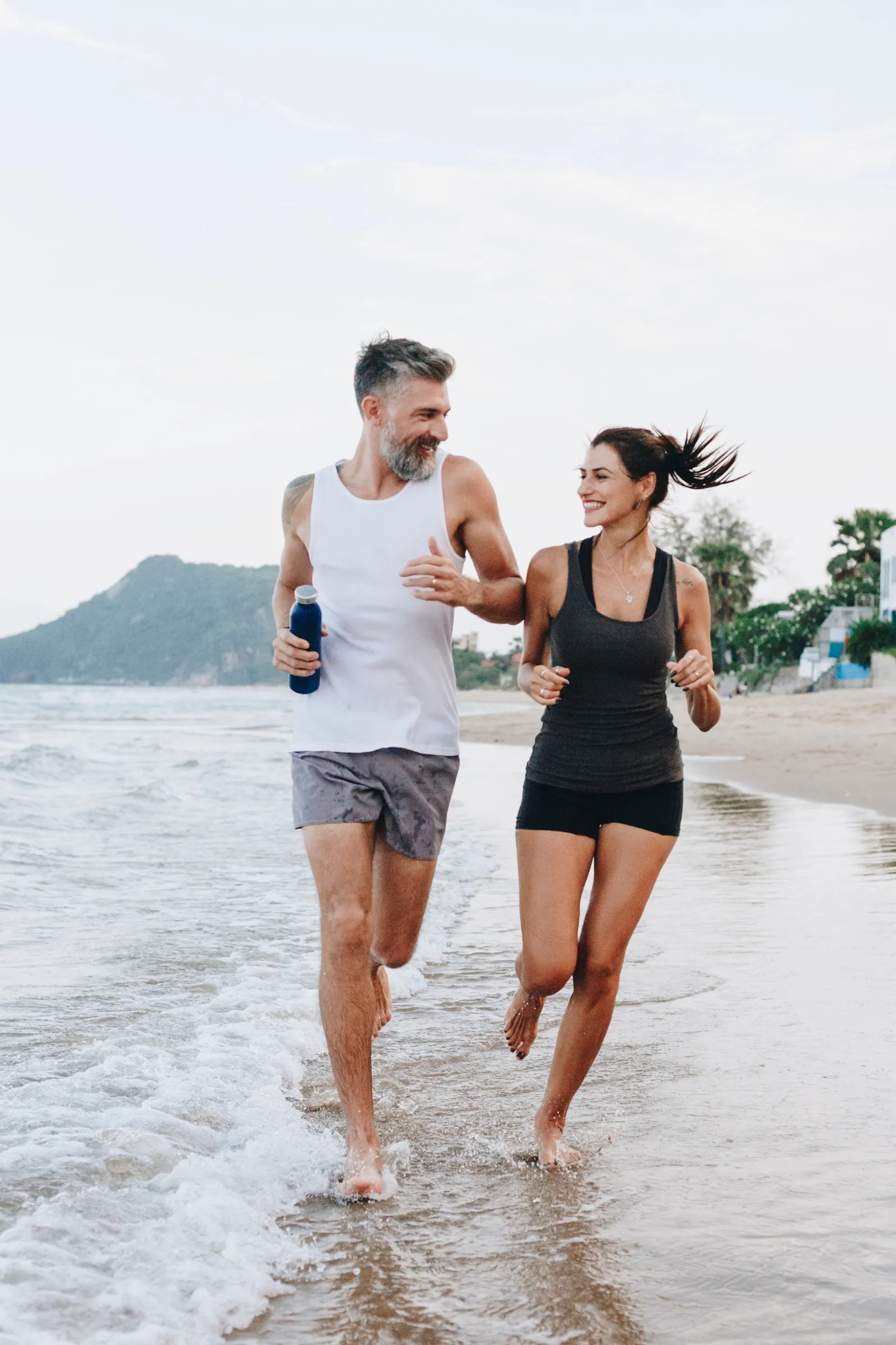 Couple jogging on beach representing sustainable weight loss results